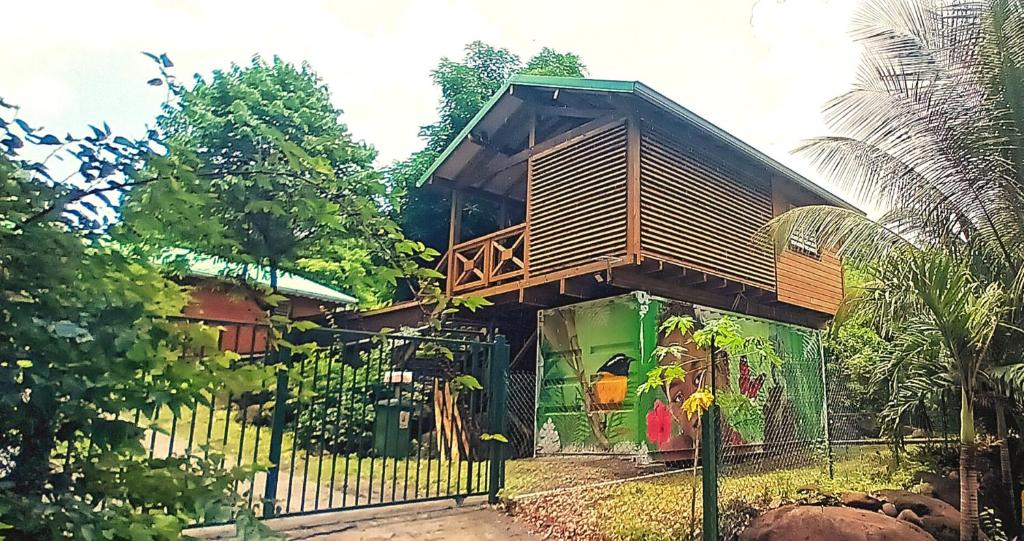 a tree house with a fence in front of it at Ti' Nid Mango Cabane charmante et confortable in Pointe-Noire