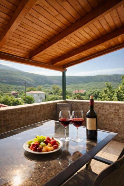 a table with two glasses of wine and a plate of fruit at Golden Island in Áno Kateliós