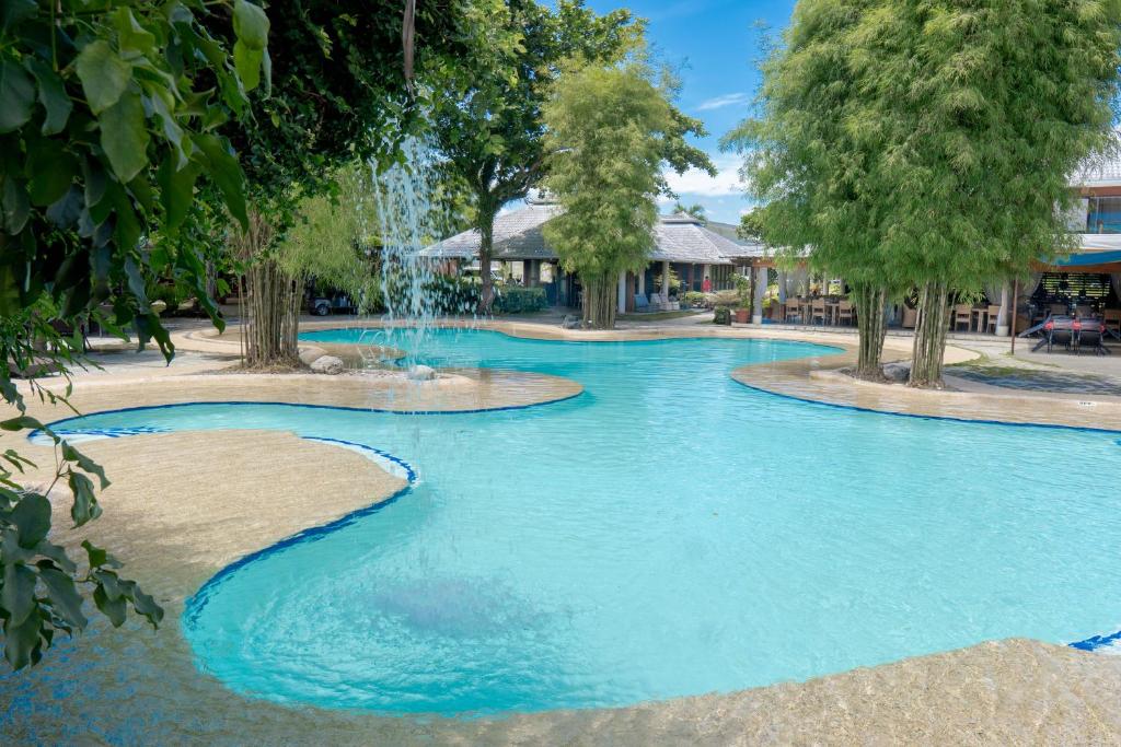 a swimming pool with a fountain in a resort at Almont Inland Resort in Butuan