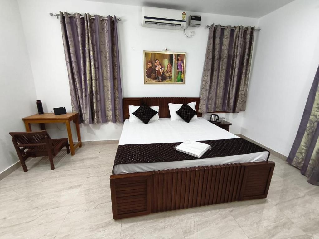 a bedroom with a bed and a table and curtains at Budget stays in New Delhi
