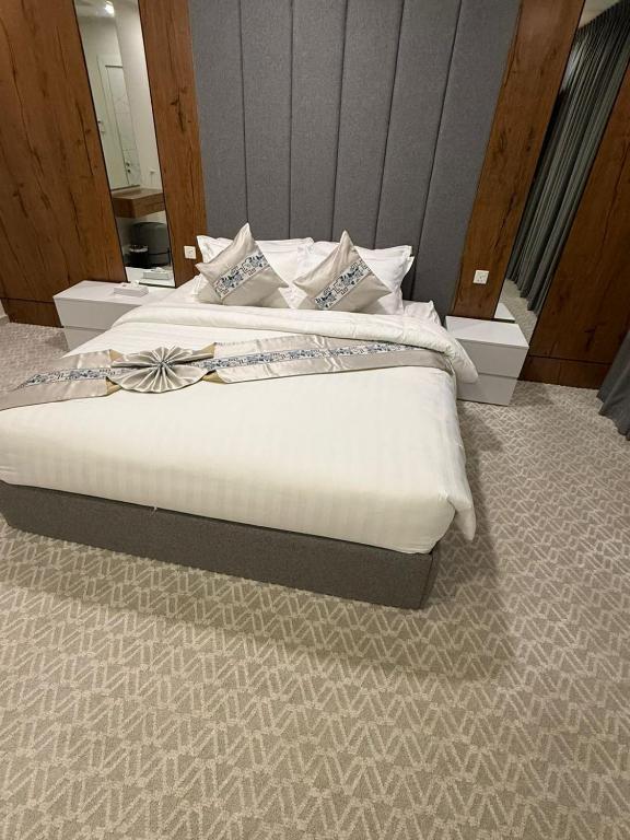 a bedroom with a bed with a bow on it at شقق كورال الفندقية in Buraydah