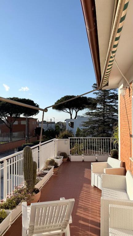 a patio with white chairs and umbrellas on a balcony at b&b la terrazza in Lido dei Pini
