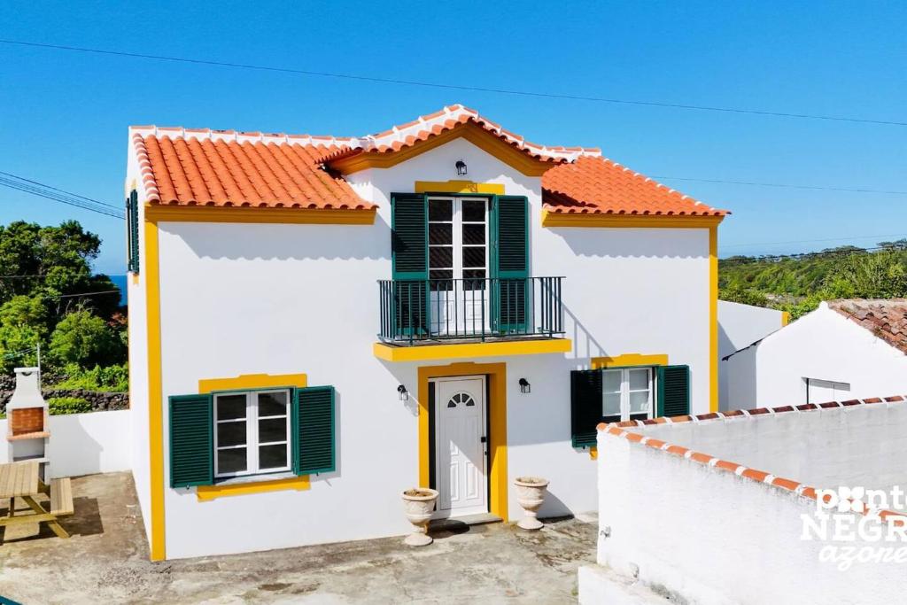 a white house with an orange roof at The Biscuit House by PontaNegraAzores in Praia da Vitória
