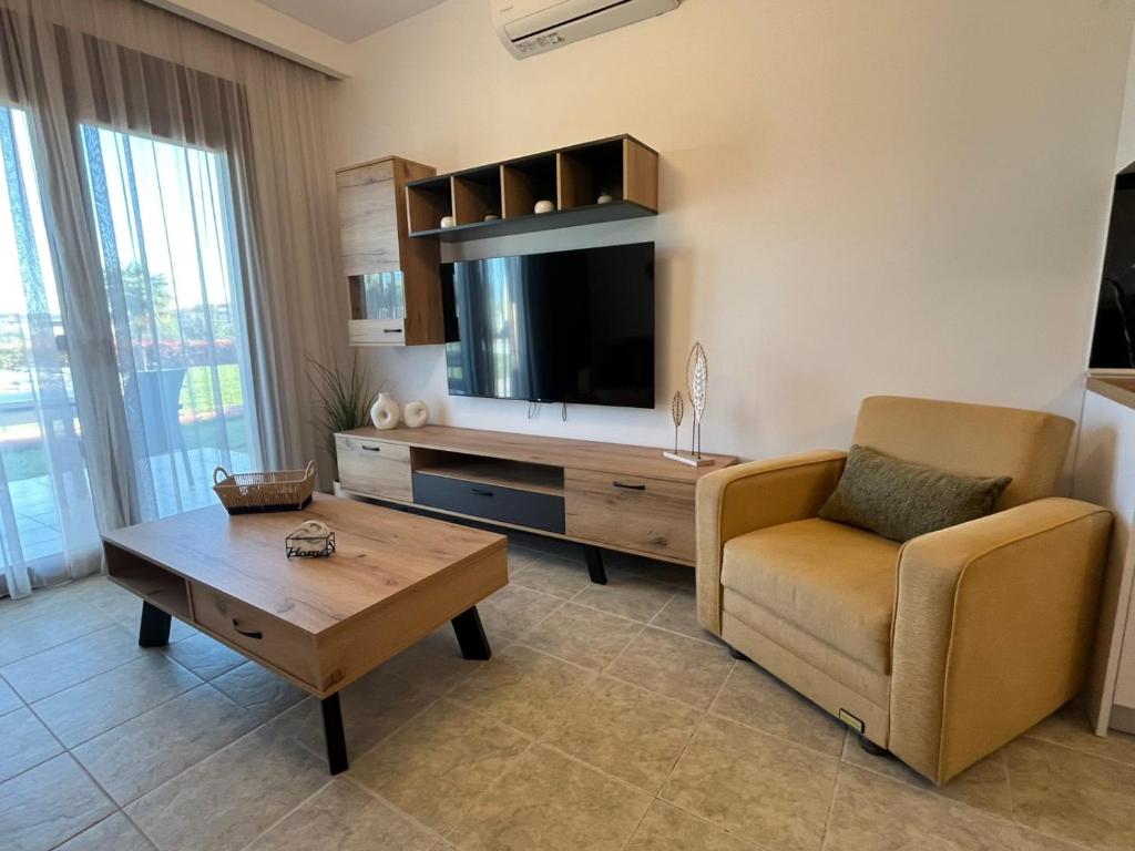 a living room with a tv and a couch and a table at Domus Afitos in Afitos
