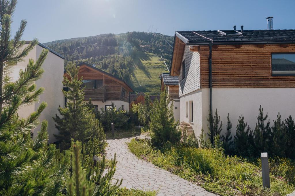 a street in a village with a mountain in the background at Katschberg Lodge in Katschberghöhe