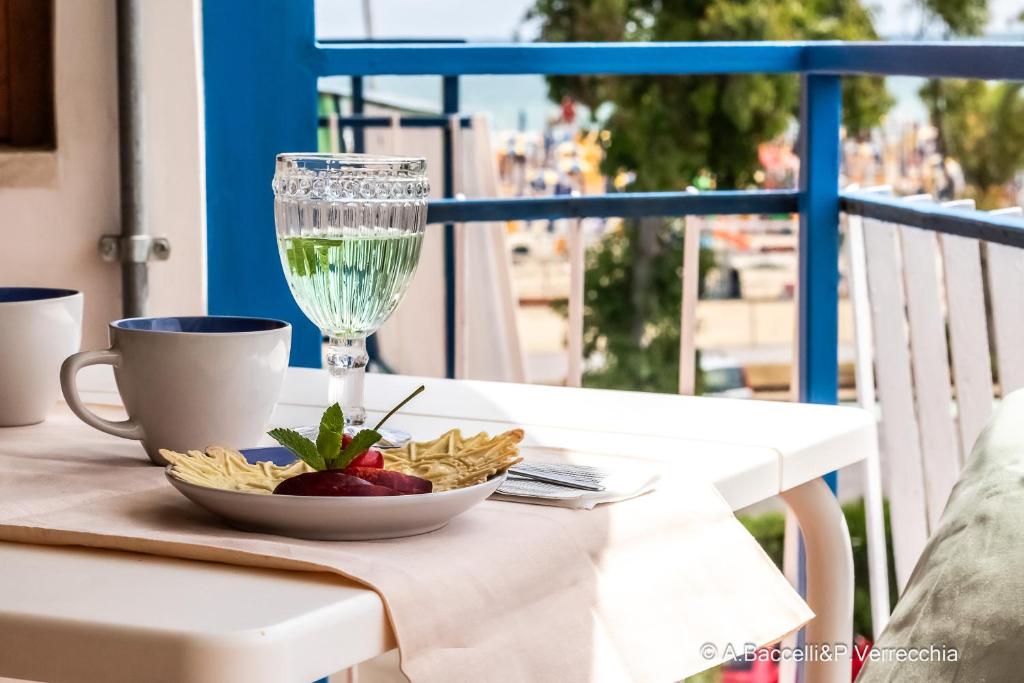 a table with a glass of wine and a bowl of pasta at Mint House in Vasto