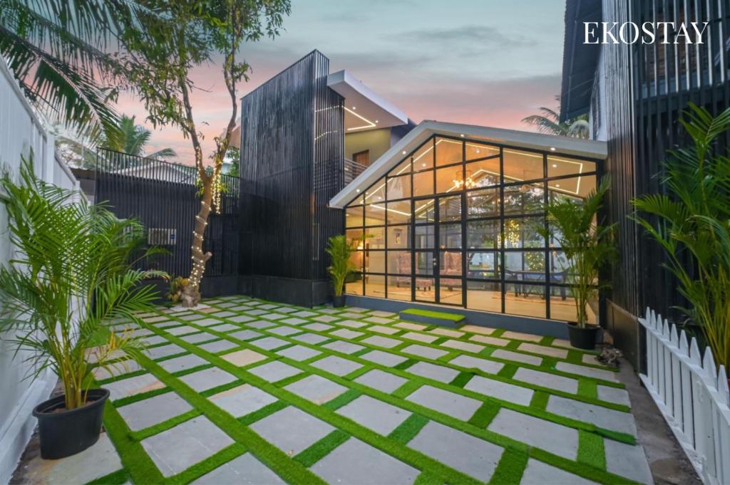 a courtyard in front of a building with plants at EKOSTAY - Noir Villa in Alibaug