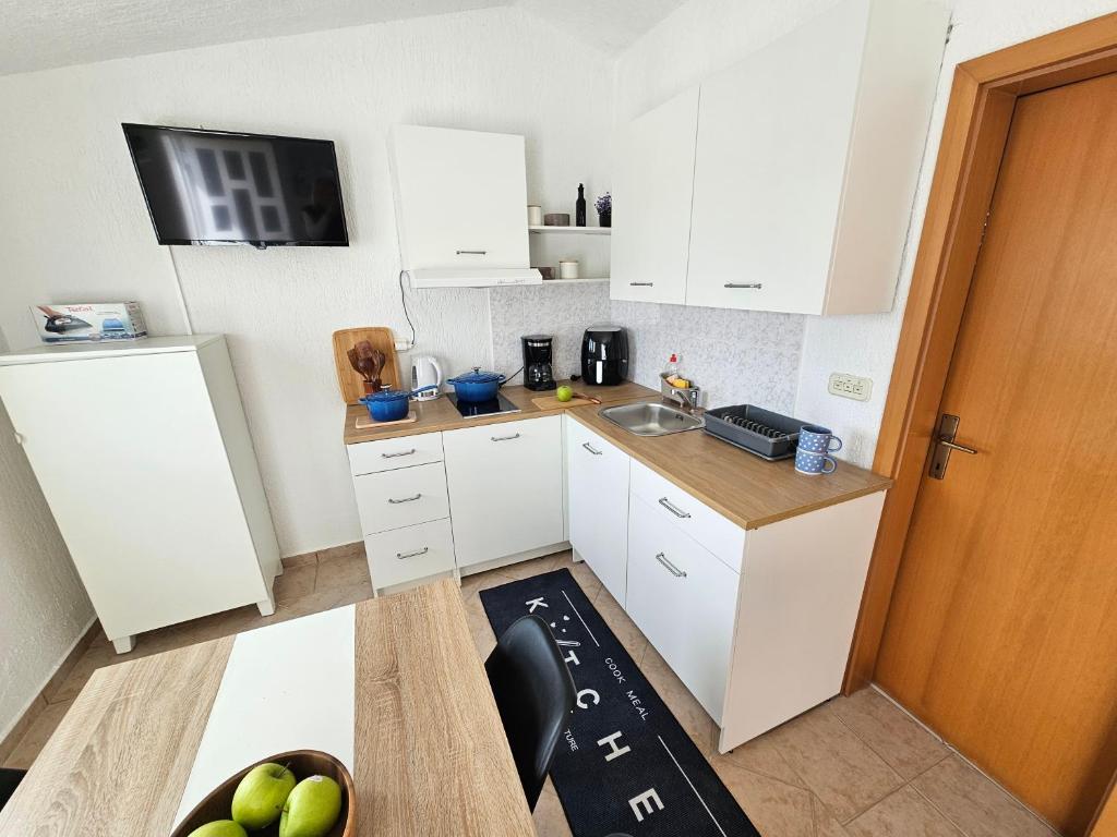 a small kitchen with white cabinets and a sink at Perla Mare in Sumartin