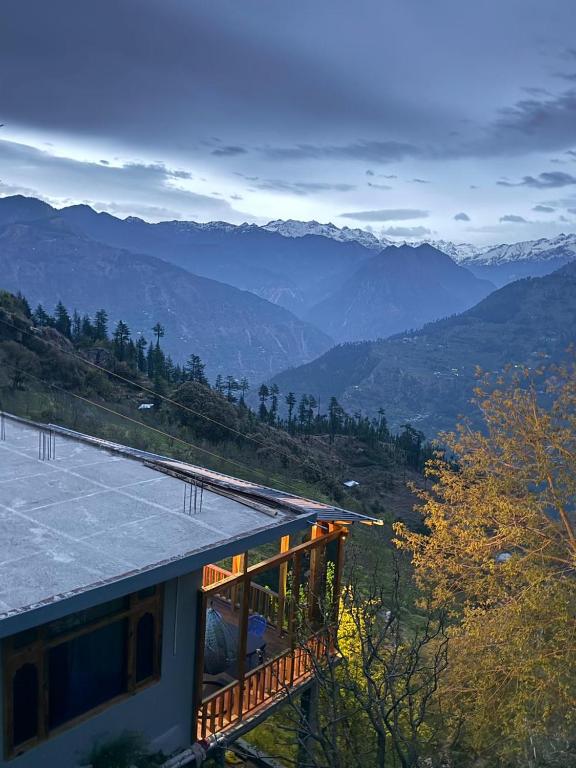 a house with a balcony with mountains in the background at Cosy Crest in Banjār
