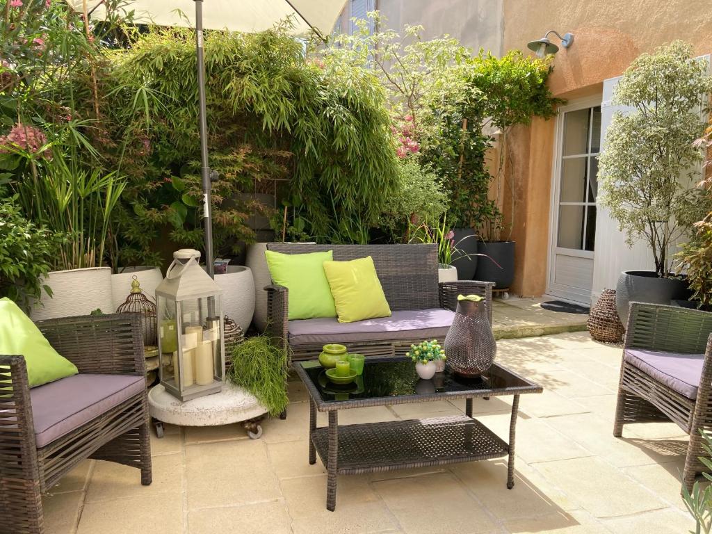 a patio with wicker chairs and a table at La Maison de Marie in Blaye