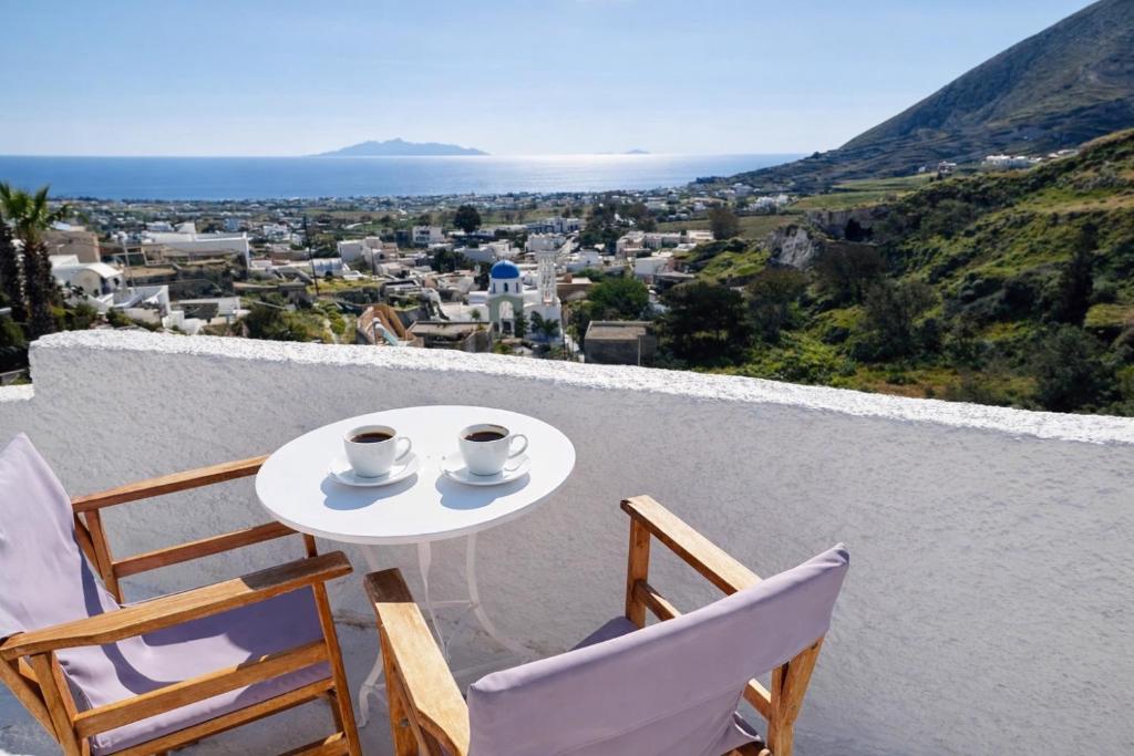 a white table with two cups of coffee on a balcony at Tiara hideaway house in Éxo Goniá
