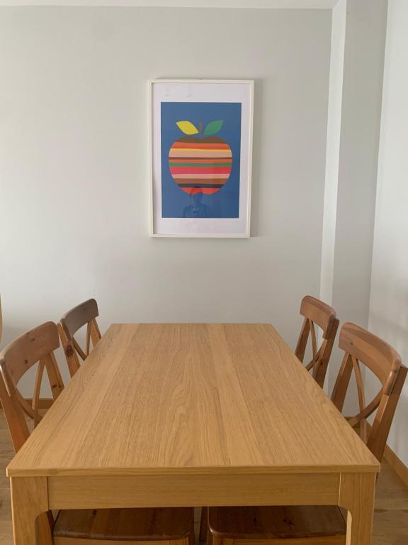 a wooden table with chairs and a picture on the wall at El Cierrón - apartamento con terrazas! in Villaviciosa