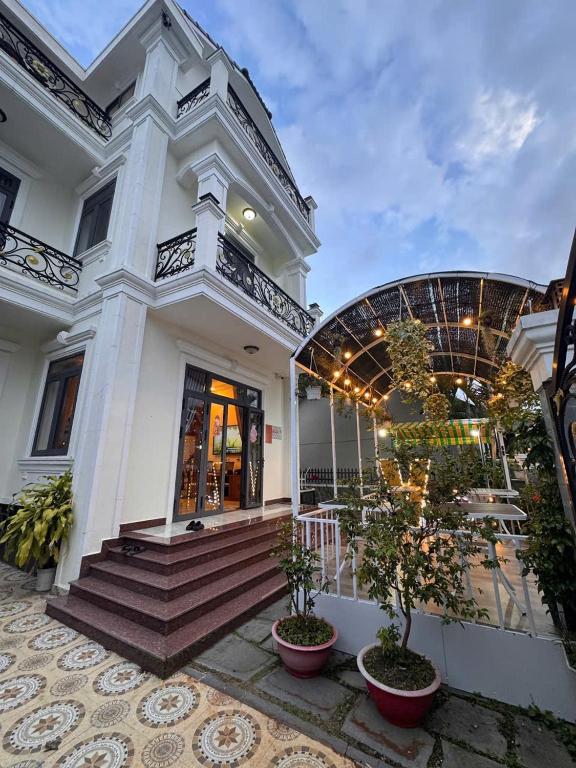 a white building with stairs and plants in front of it at Carol Dalat in Khu Chi Lăng