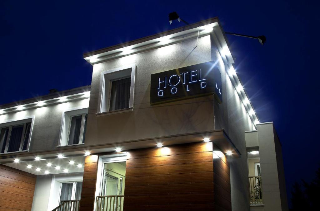 a hotel sign on the side of a building with lights at Hotel Gold in Poznań