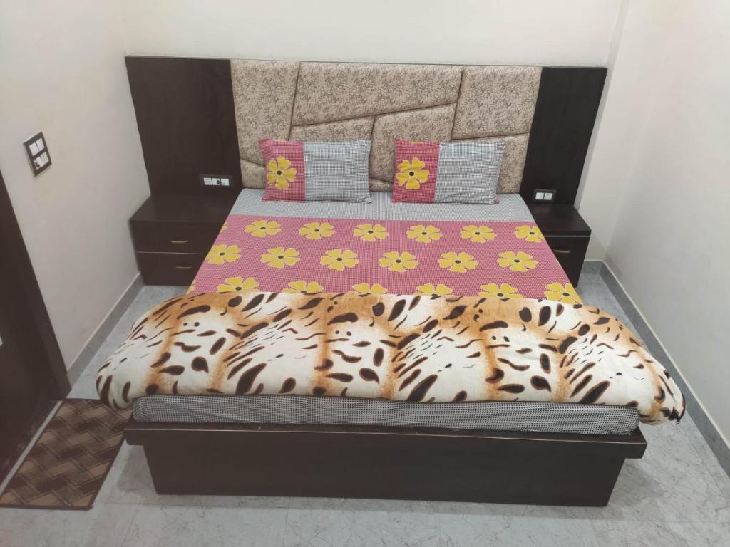 a bedroom with a bed with a leopard print bedspread at Shri Shyama seva kunj in Vrindāvan