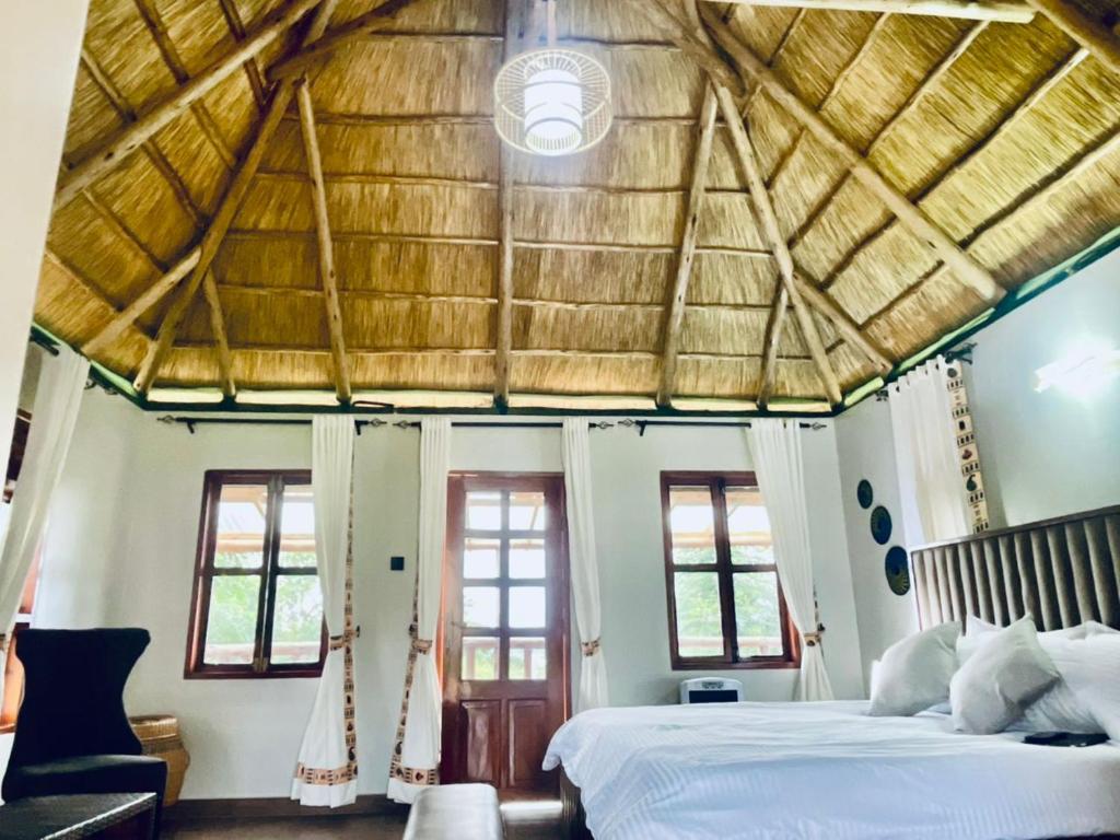 a bedroom with a large bed with a wooden ceiling at Ewafe Safari Lodge-Murchison in Wanseko