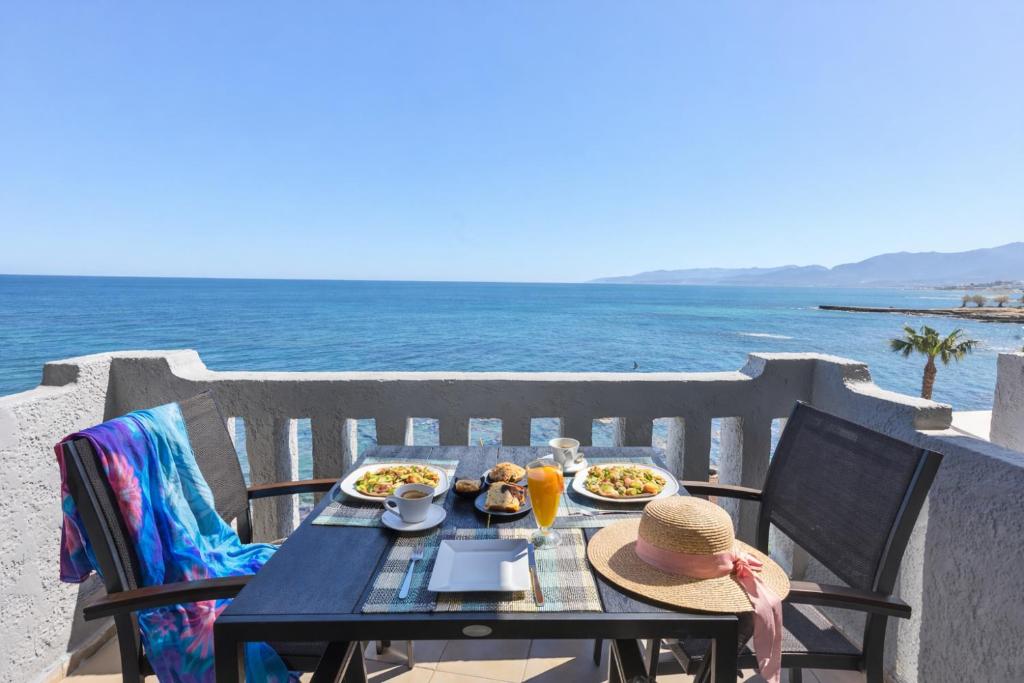 a table with food on it with a view of the ocean at Arlen Beach Hotel in Hersonissos