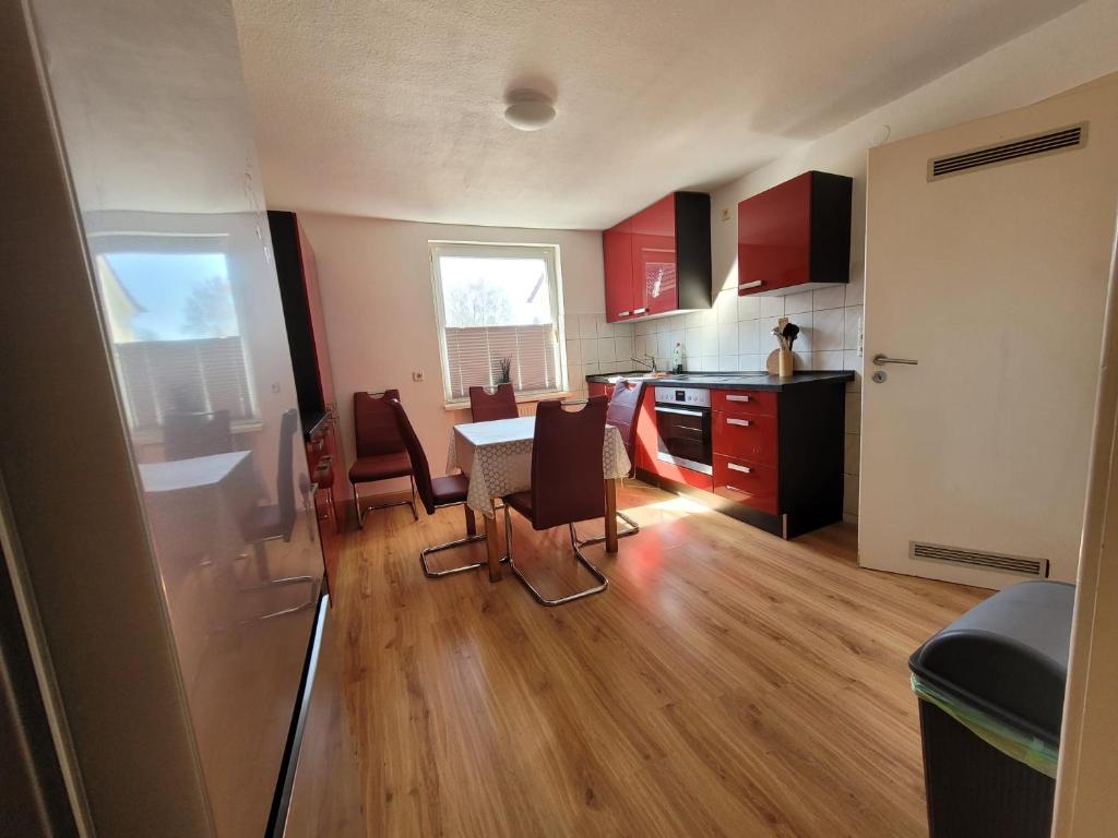 a kitchen with red cabinets and a table and chairs at Charlotte II in Neustadt bei Coburg