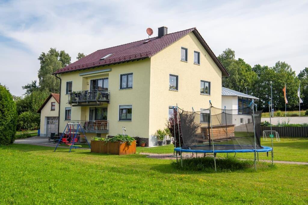 a house with a playground in front of a house at Haus Heidi mit Balkon in Moosbach