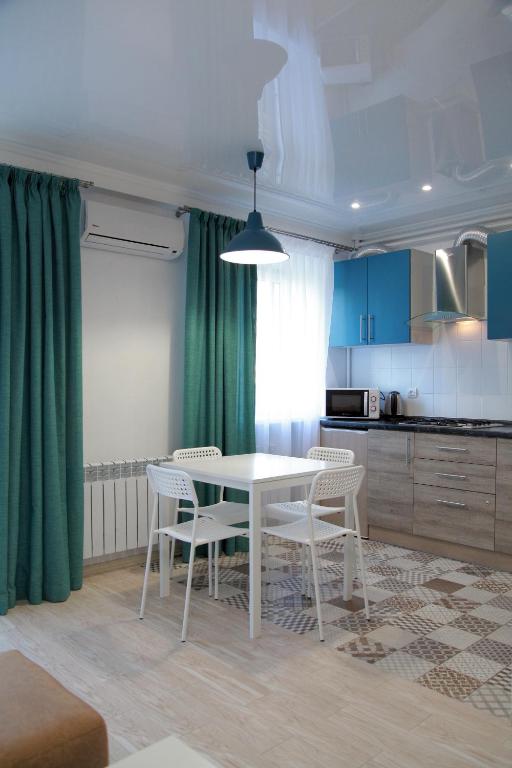 a kitchen with a table and chairs in a room at Люкс с 2-мя спальнями в ЦЕНТРЕ in Mykolaiv