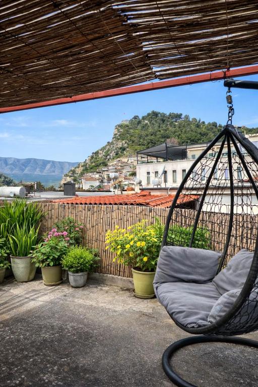 a swing hanging on a balcony with potted plants at Jemin Apartment in Berat