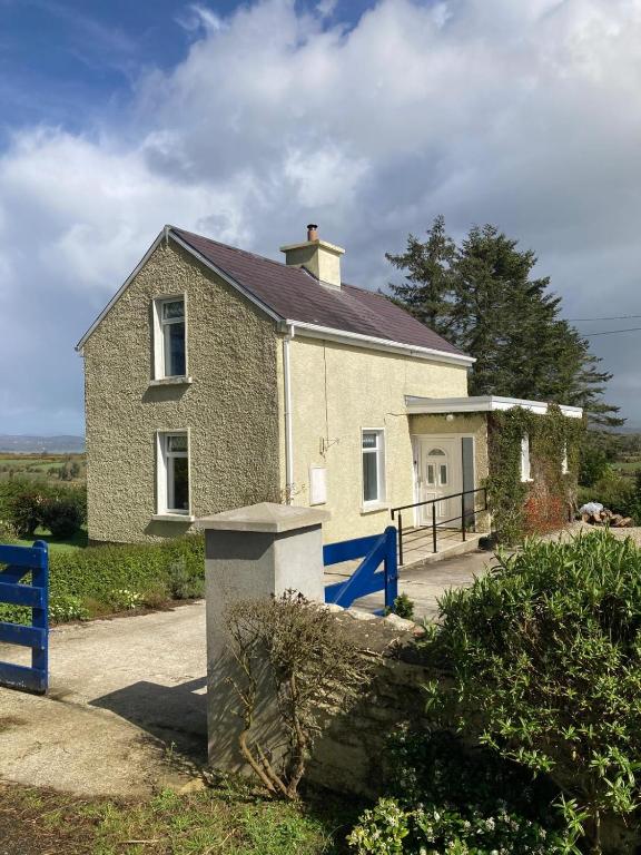 a house with a blue fence in front of it at The Cottage in Ramelton
