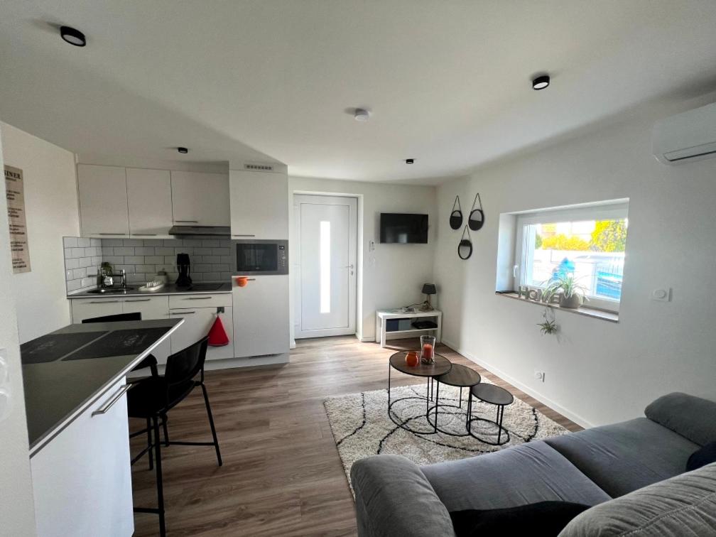 a kitchen and living room with a couch and a table at Le Gîte des petits Loups in Walbourg