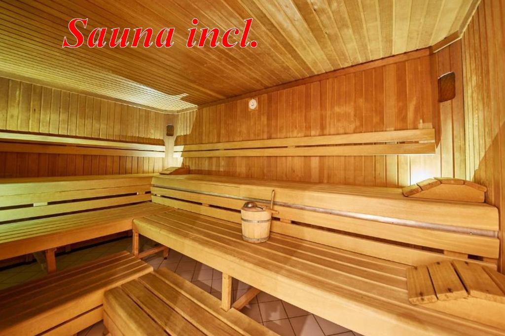 a sauna with wooden benches and a bucket in it at Ferienwohnung Loitfelder-Pang in Saalbach-Hinterglemm