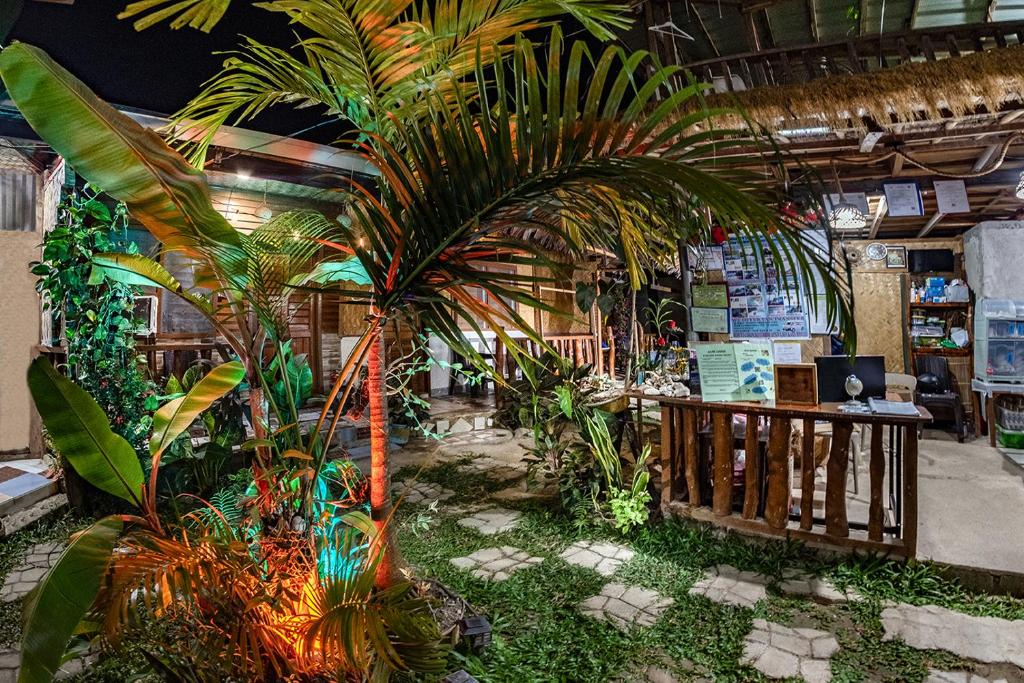 a room with palm trees and plants in it at ALFA Garden Lodge in El Nido