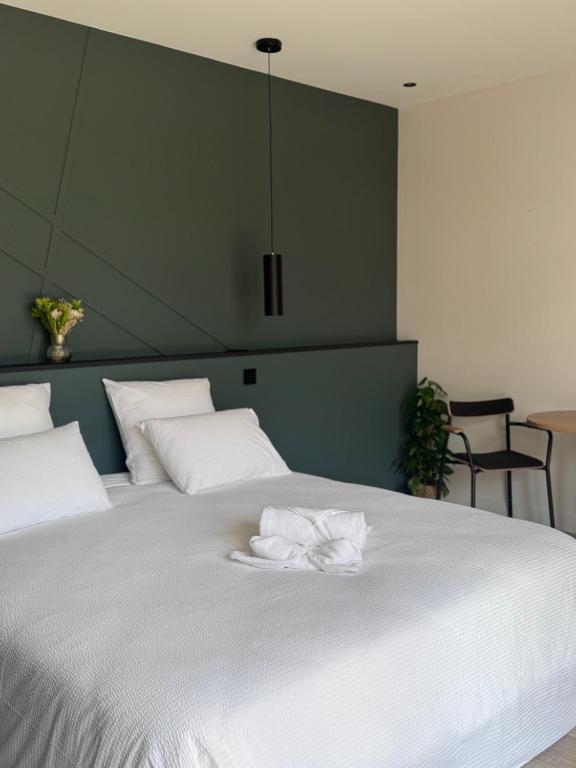 a large white bed with two white towels on it at Gîtes les rives de Saône in Saint-Didier-sur-Chalaronne