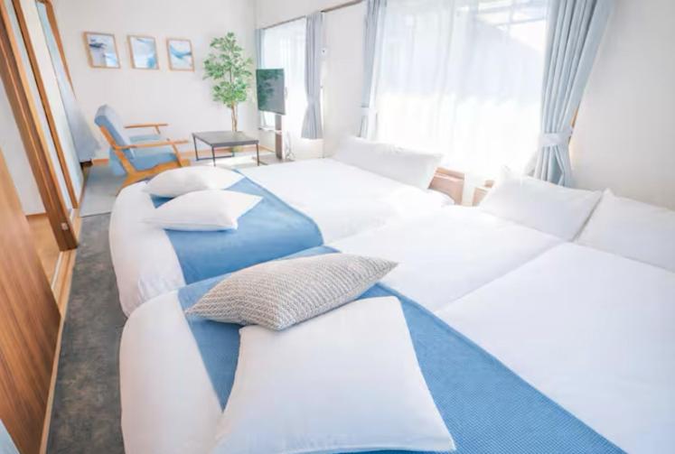 a bedroom with two beds and a couch and a room at REKADO ROOM Kengun in Kumamoto