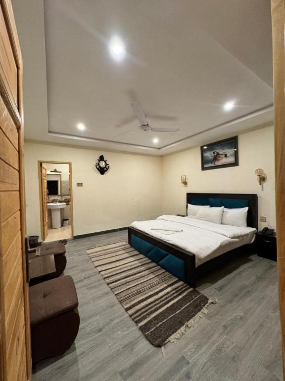 a bedroom with a large bed with a blue frame at Pak Himalaya Hotel Kachura in Ponedas