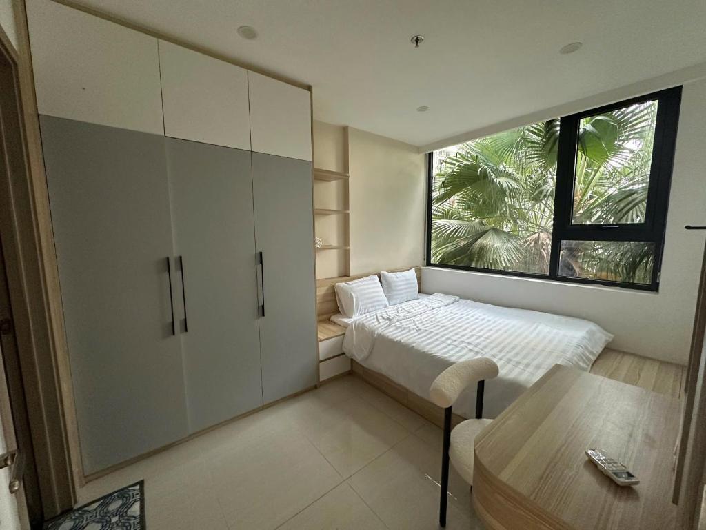 a small bedroom with a bed and a window at Hue Oi 5 Homestay - Spacious 2-Bedroom Apartment with Balcony & Pool in Hue