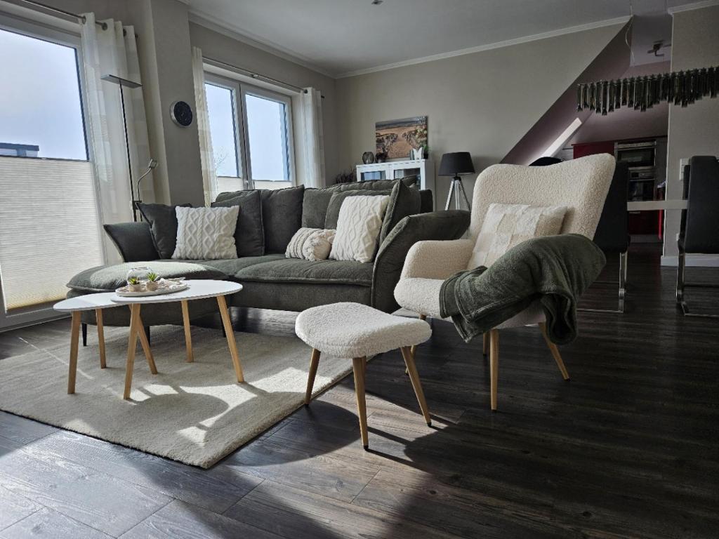a living room with a couch and two chairs and a table at Fewo Baltic Dreams in Börgerende-Rethwisch