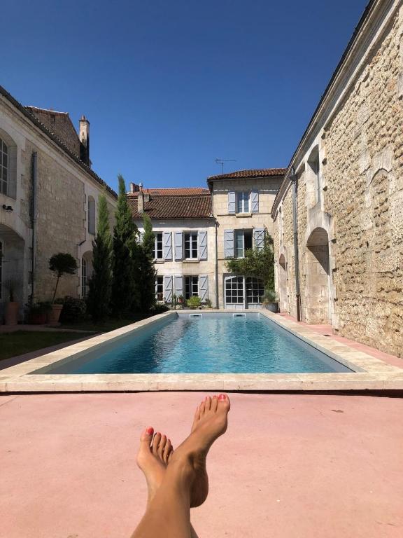 a person laying on the ground near a swimming pool at Le Bon Appart in Angoulême