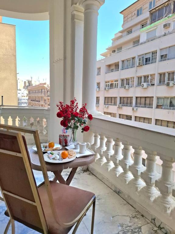 a table and chairs on a balcony with a table and flowers at Dawn town palace in Cairo