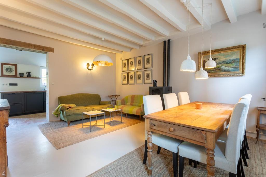 a dining room and living room with a table and chairs at Clos Chartrain in La Chartre-sur-le-Loir