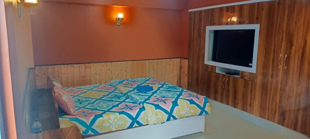 a bedroom with a bed and a flat screen tv at indrapuri homestay in Darjeeling