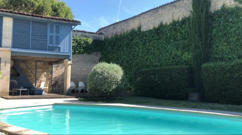 a swimming pool in a yard next to a building at Large house - Garden pool in Cognac