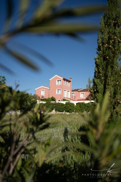 a pink house in the middle of a field at Villa Arta in Drage