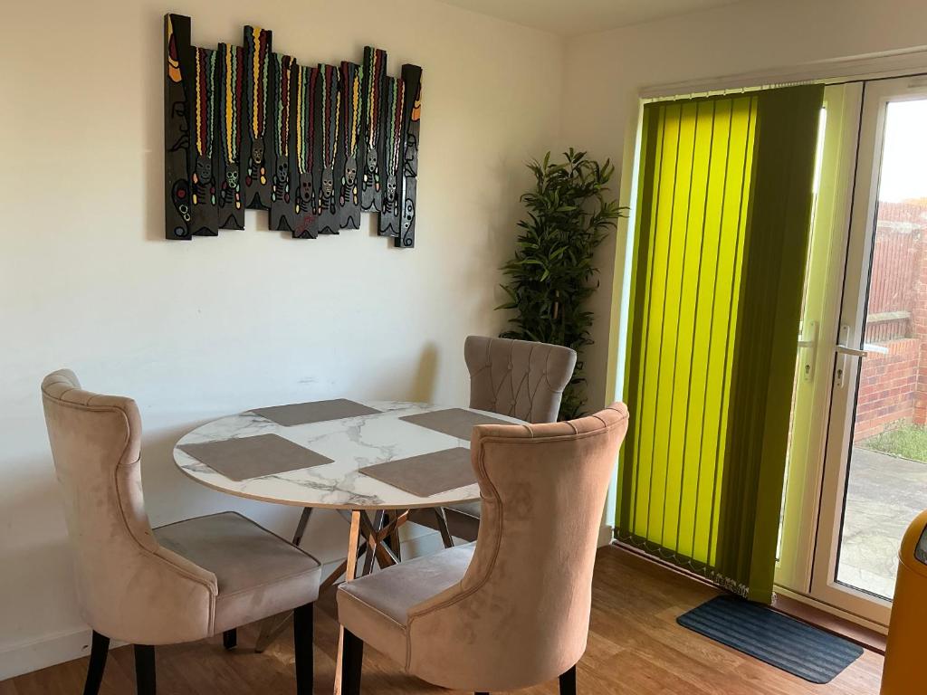 a dining room with a table and four chairs at Home away from away in Dartford