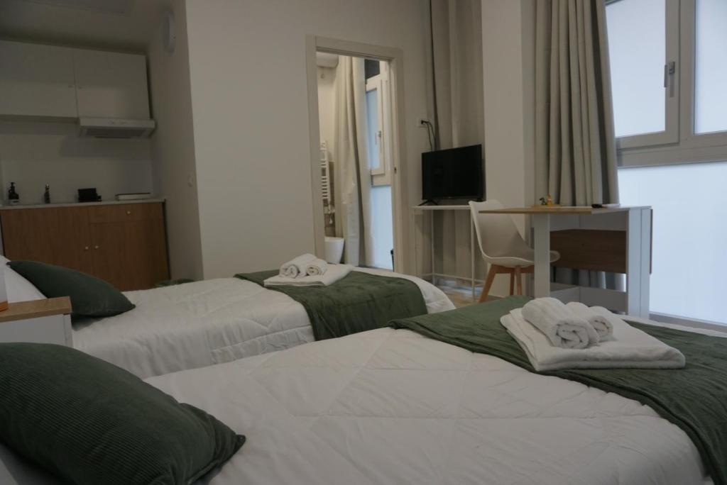 a hotel room with three beds with towels on them at Casa Sangiorgio Srl in Treviglio
