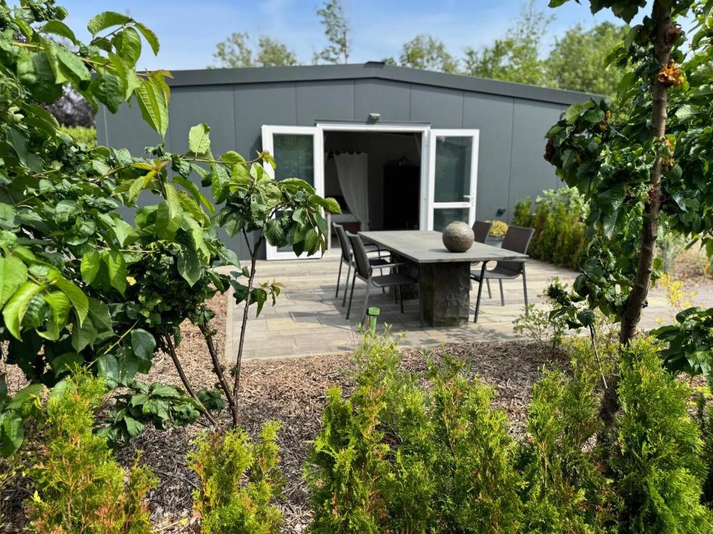 a garden with a table and chairs in front of a building at Private Apartment Retreat in Breda