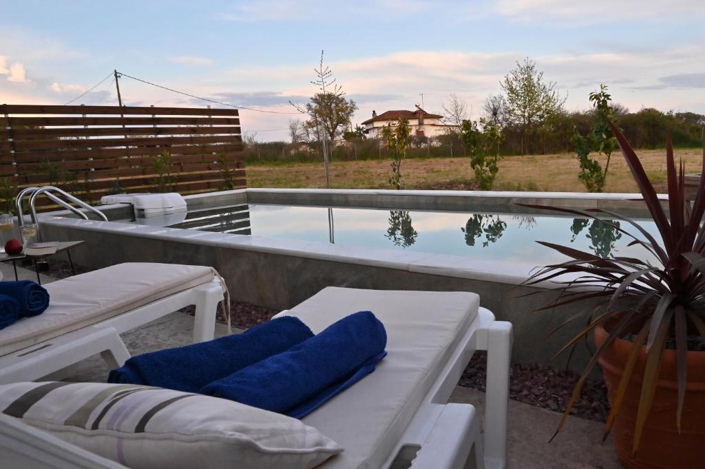 a swimming pool with two lounge chairs and a tub at Olympus Pool Retreat in Katerini