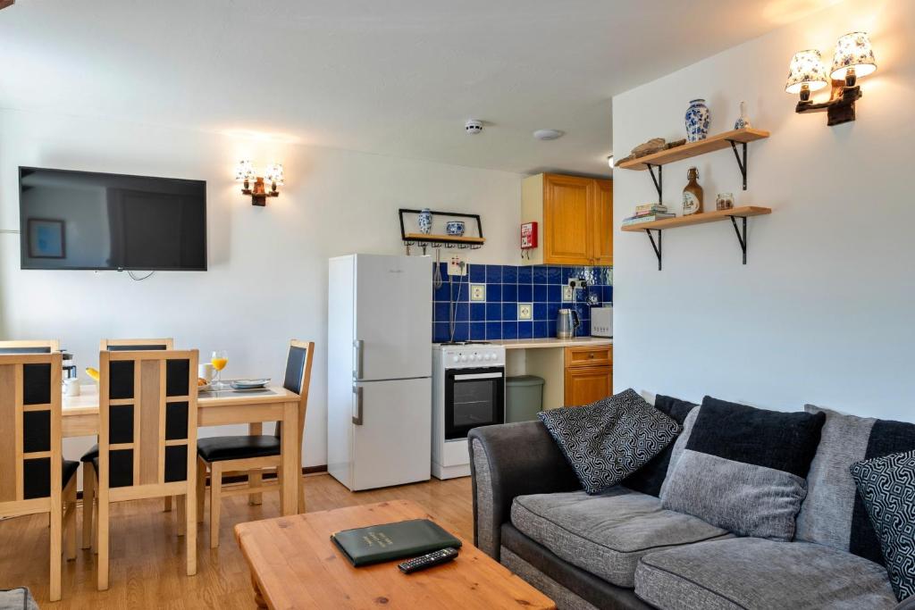 a living room with a couch and a kitchen at Finest Retreats - Trimstone Manor, Manor Cottage in Woolacombe