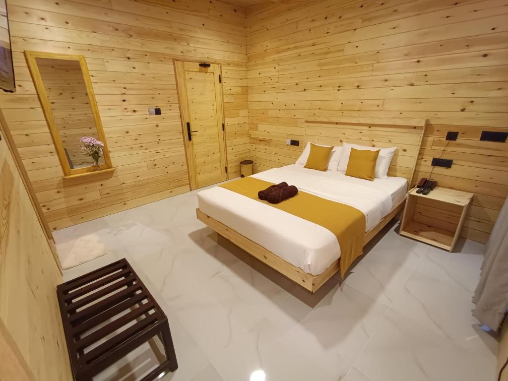 a bedroom with a bed in a wooden room at Wood Gold Ella in Ella
