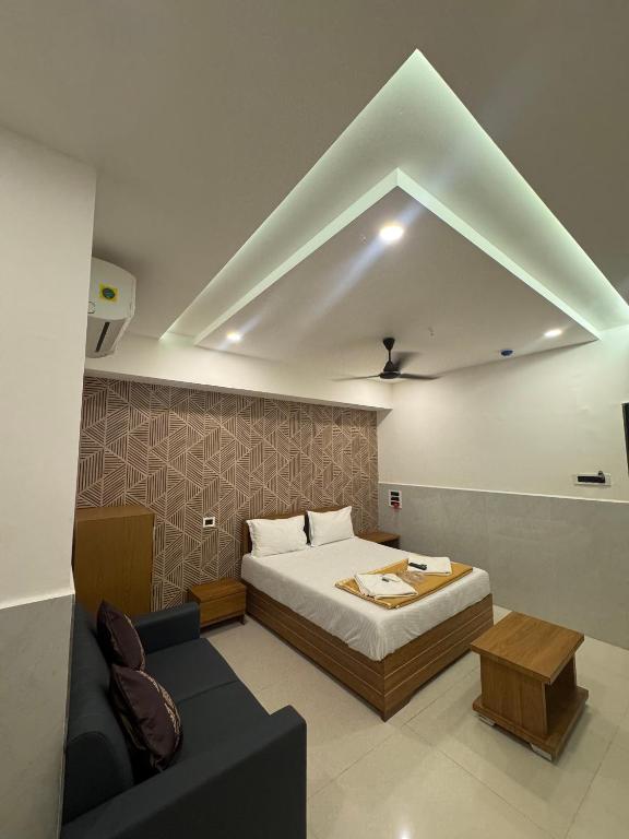 a bedroom with a bed and a couch in a room at Hotel Kalp Rooms in Vyāra