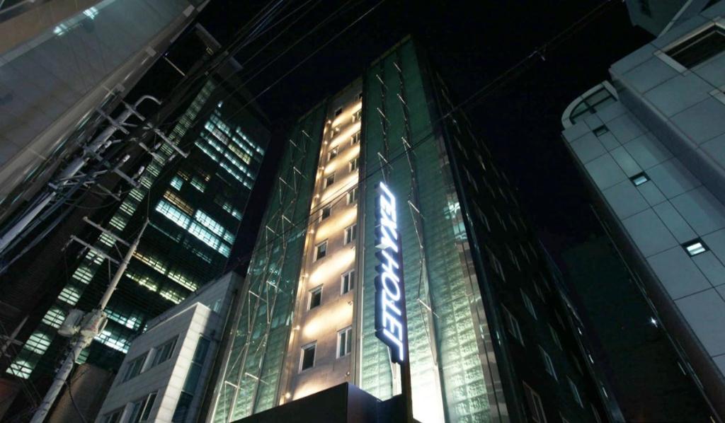 a tall building with a sign on it at night at 렉시호텔 in Seoul