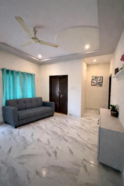 a living room with a couch and a ceiling fan at Vididhi By N - 2BHK Neo Stay in Kottapeta