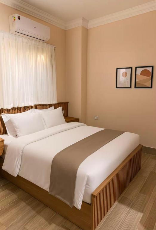 a bedroom with a large white bed with a window at DEight by The Dream Stays in New cairo